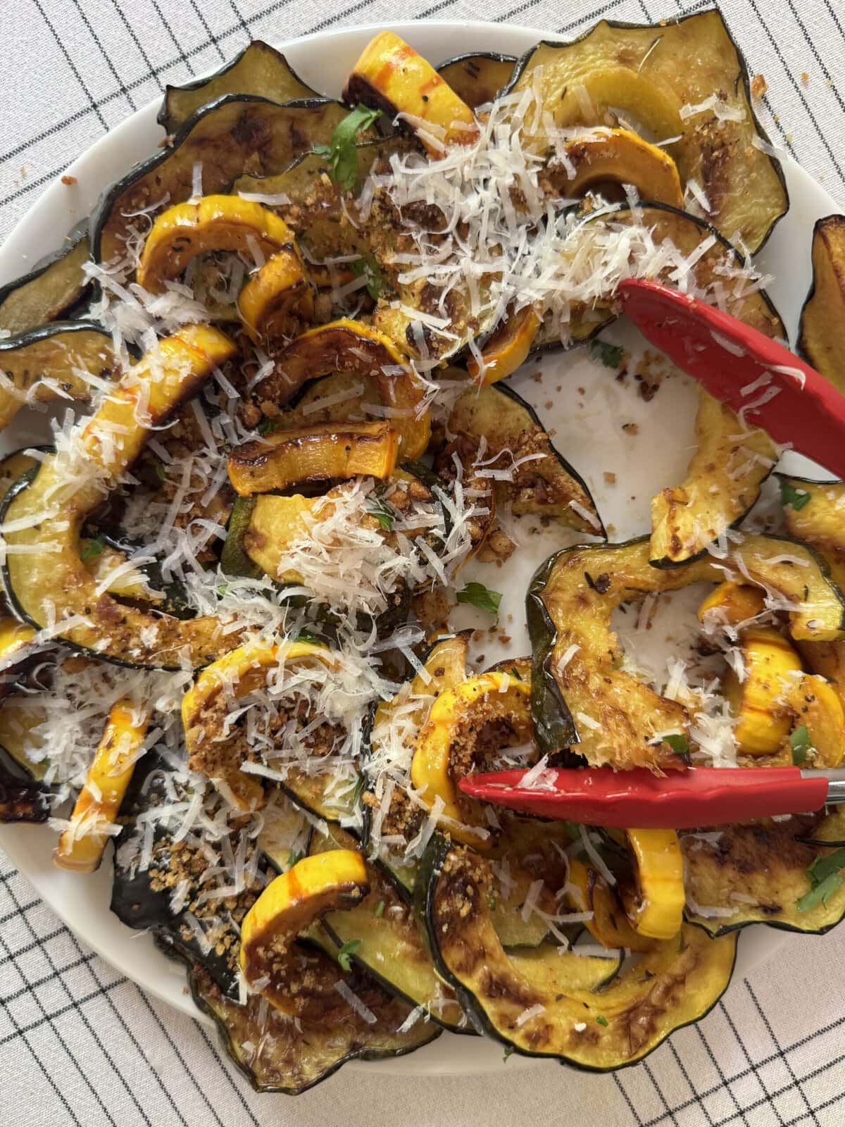 Delicata squash with breadcrumbs and parmesan and serving tongs