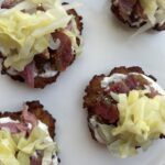 Overhead image of finished product: potato latkes with corned beef and cabbage, on white platter.
