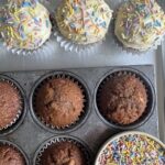 Overhead shot of Carrot and Banana Muffins. Some with frosting and sprinkles, some bare.