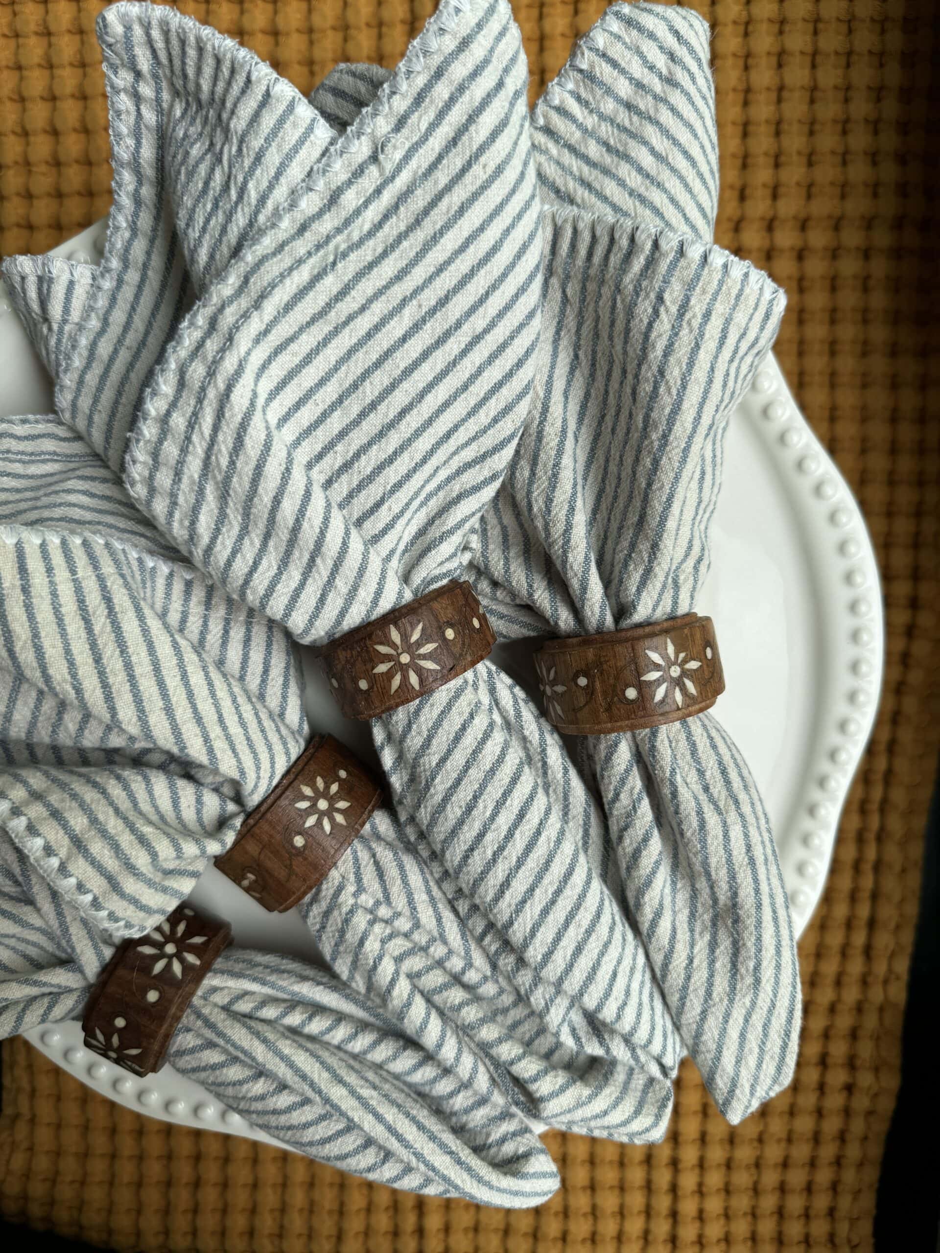 Arrangement of striped cloth napkins with wood holders. About the host notes