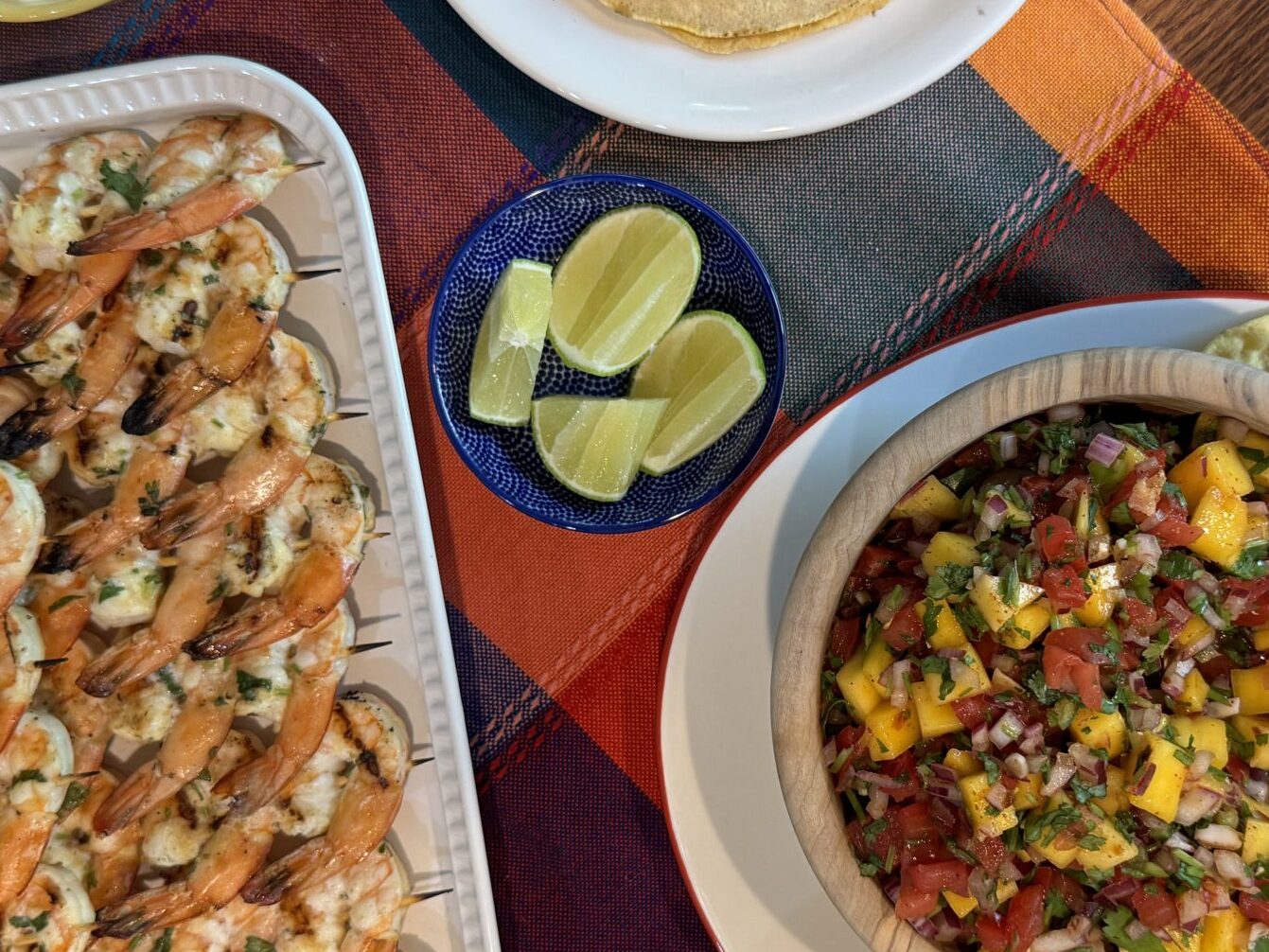 Full dinner spread of Fresh Mango Salsa with grilled shrimp, tortillas, and accoutrements. 