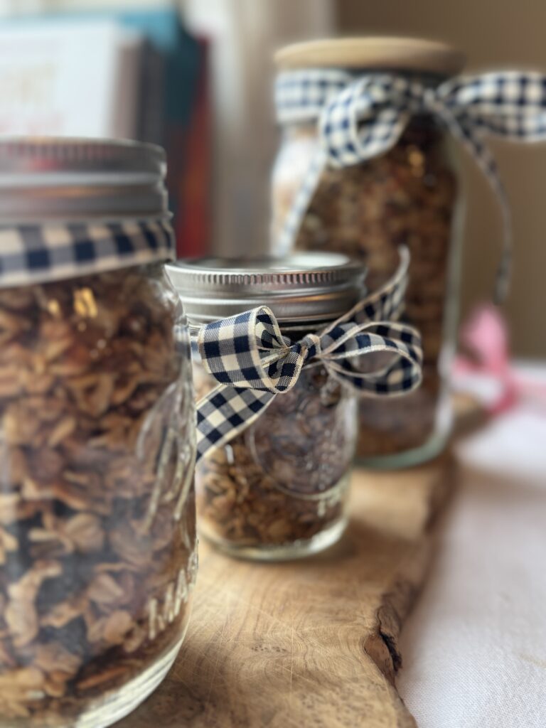 Finished Gluten-Free-Granola in Mason jars with blue and white checked ribbon. Ready for gifting.