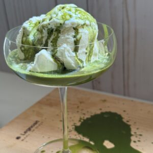 Vanilla ice cream served in a coupe glass with green matcha tea poured over top.