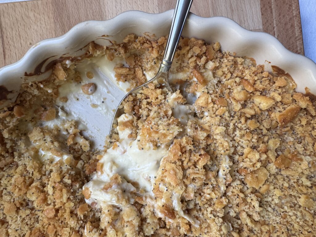 Chicken Poppyseed casserole with serving spoon, ready to dish-up.