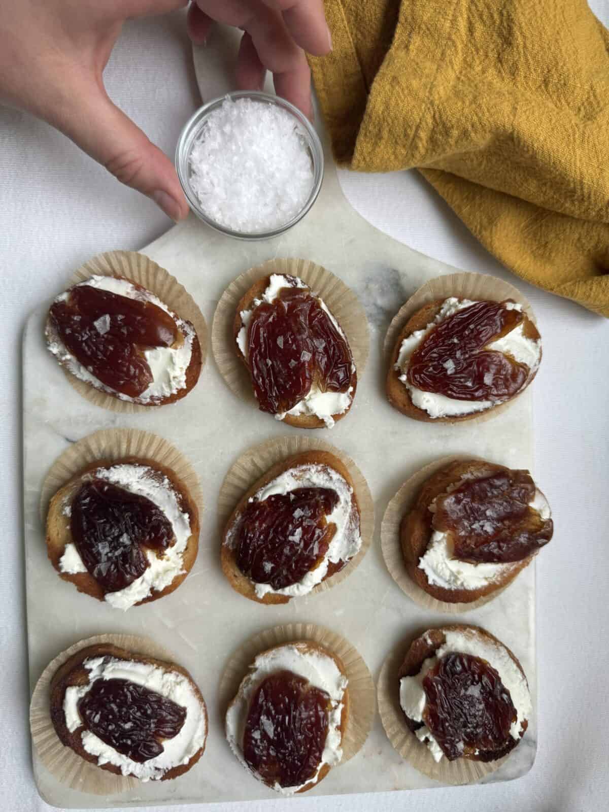 Goat cheese and date crostini on a platter.