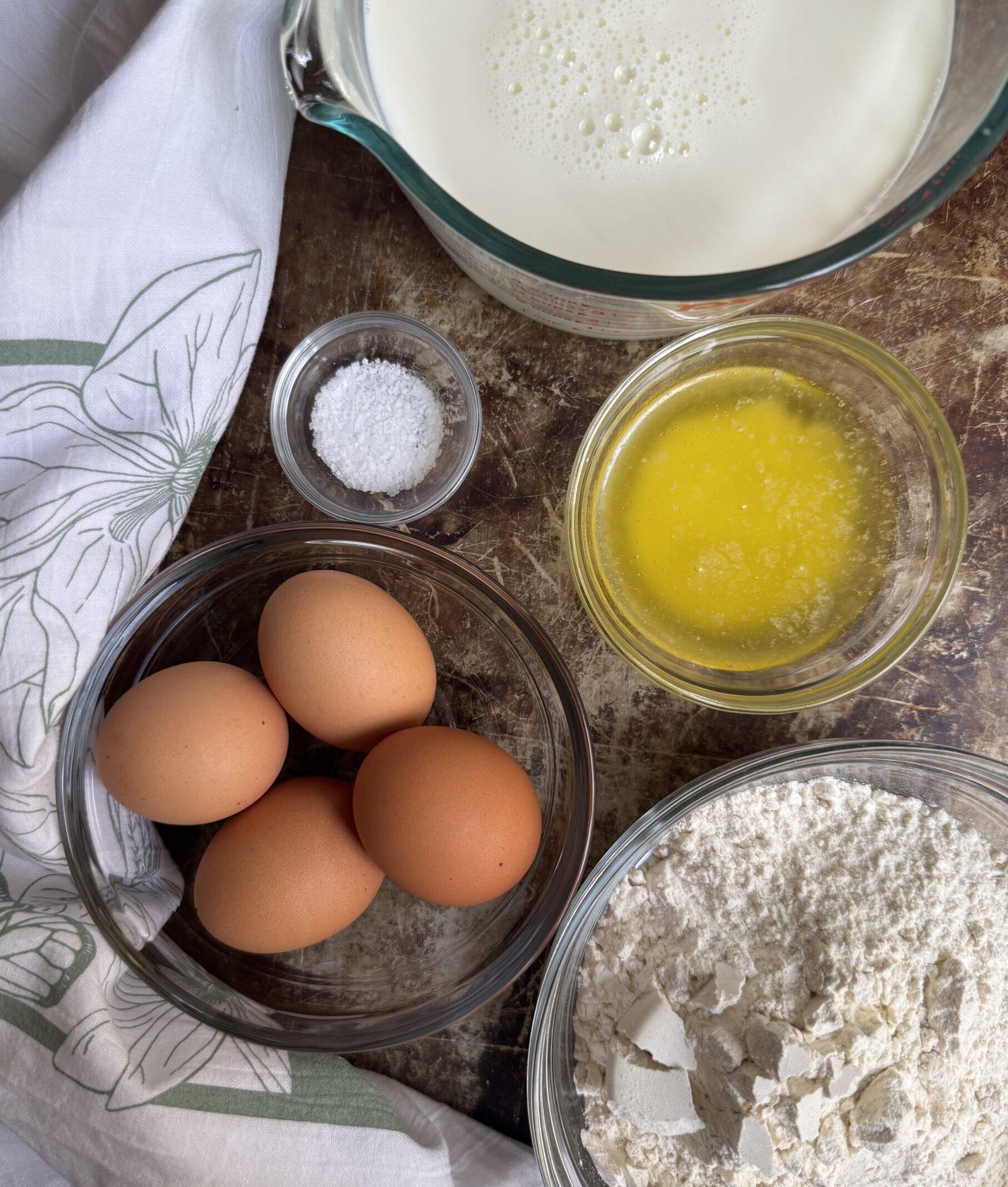 Ingredients for simple crepes: whole milk, eggs, melted butter, flour, and salt.