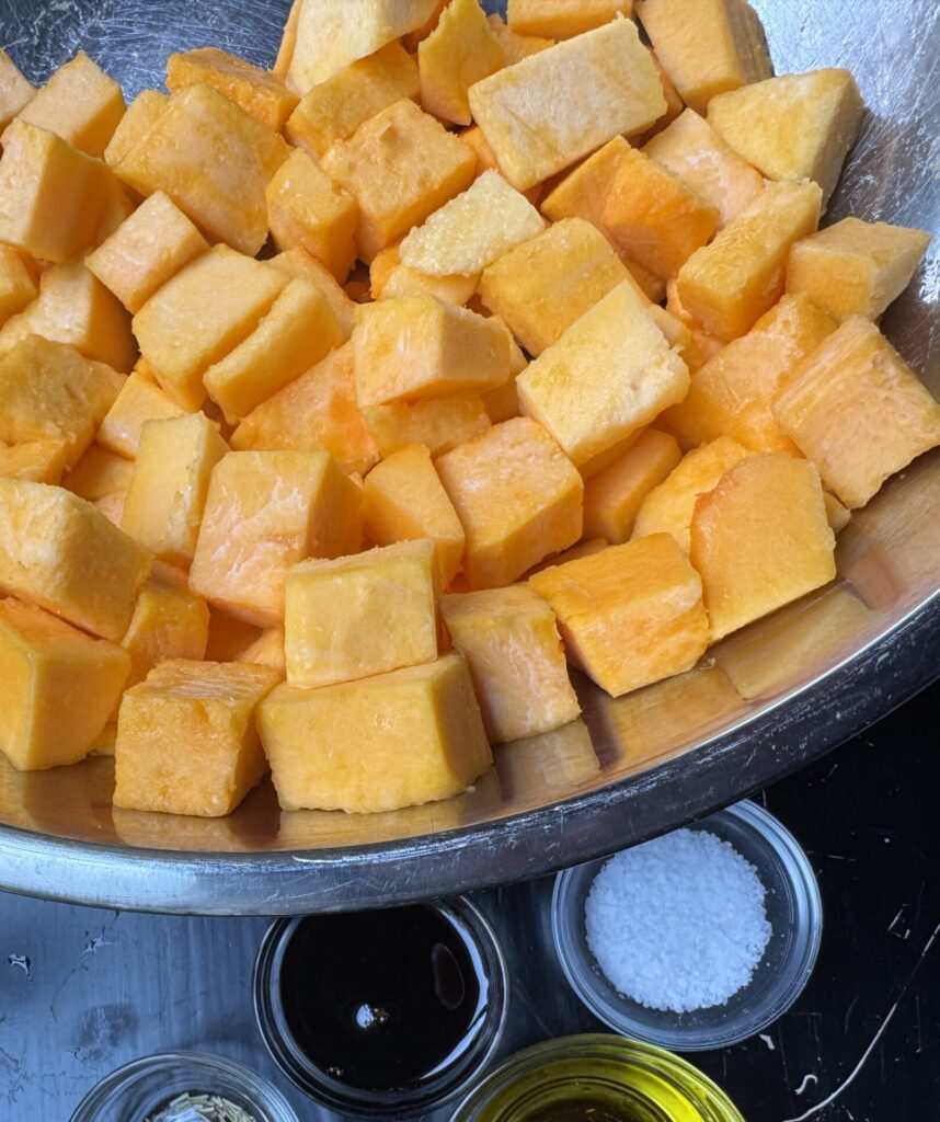 Raw ingredients: cubed butternut squash, olive oil, spices, balsamic.