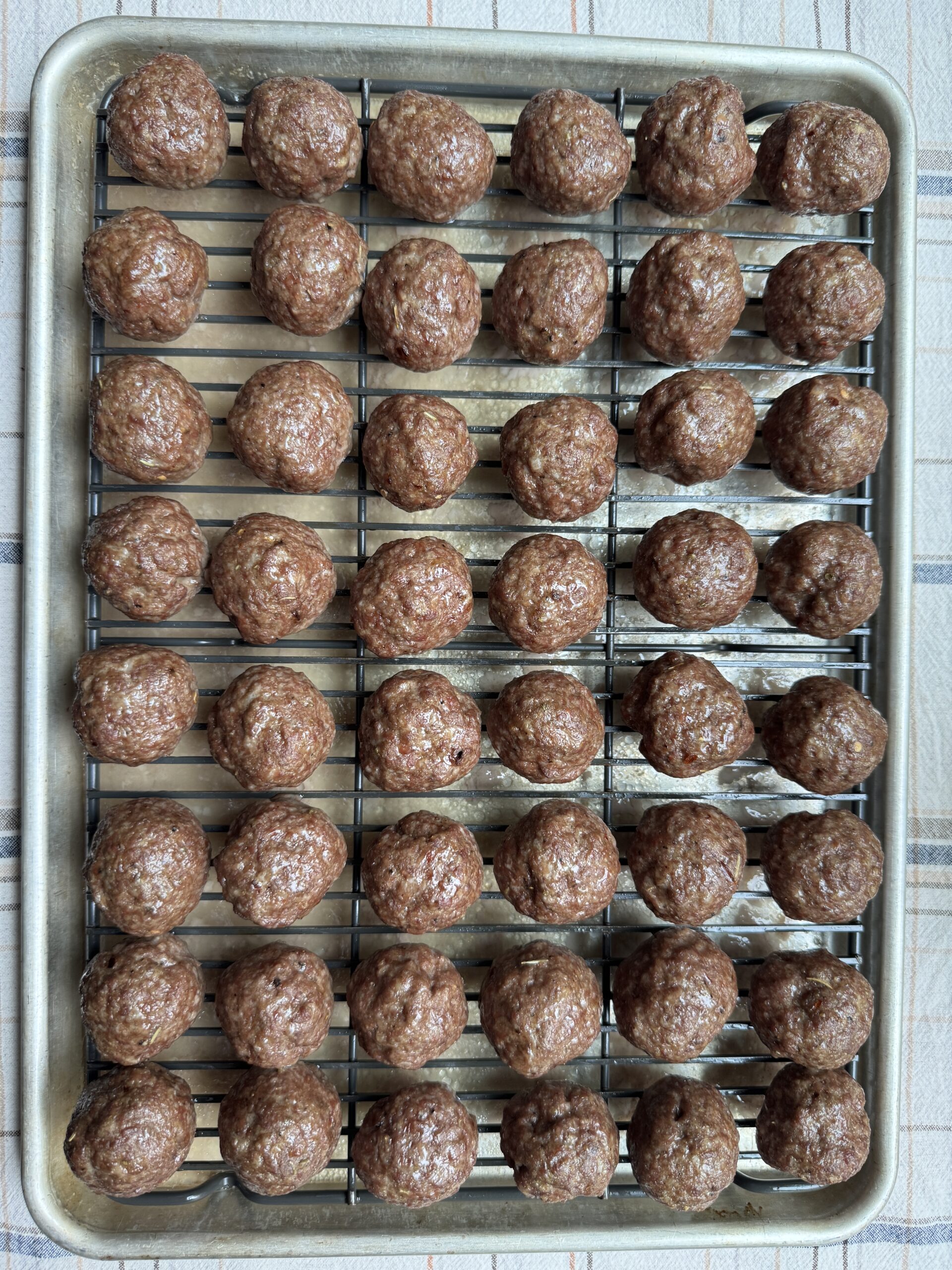 Baked meatballs on a baking sheet.