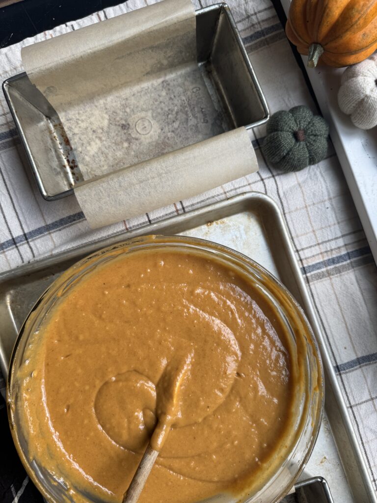 Pumpkin Bread batter in a bowl alongside a loaf tin.