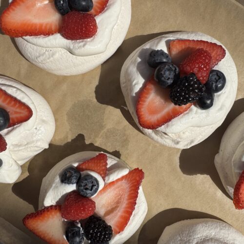 Mini Pavlova Nests with Vanilla Bean Whipped Cream, and an assortment of fresh berries.