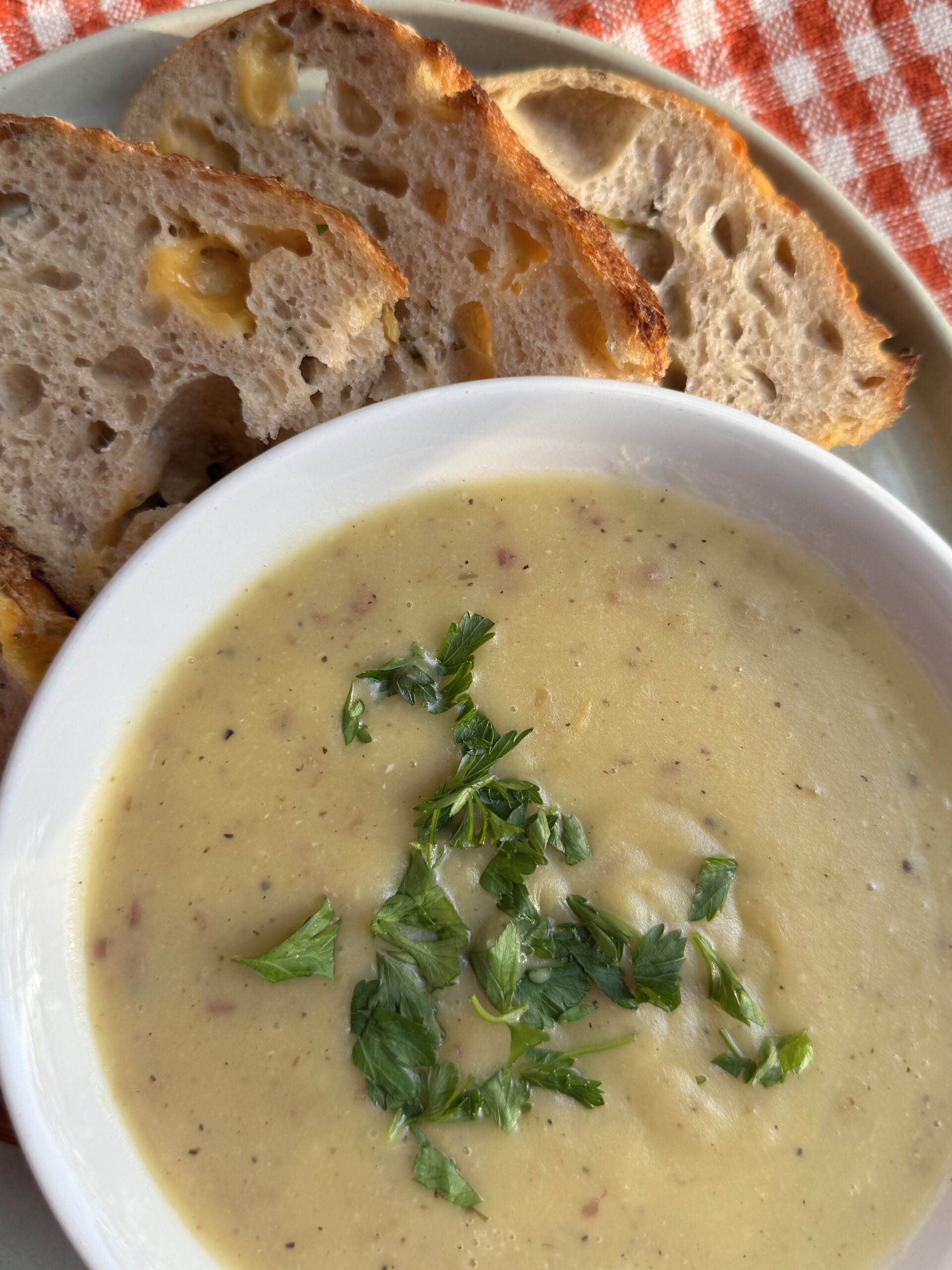Creamy potato leek soup without cream served with cheddar and chive sourdough bread