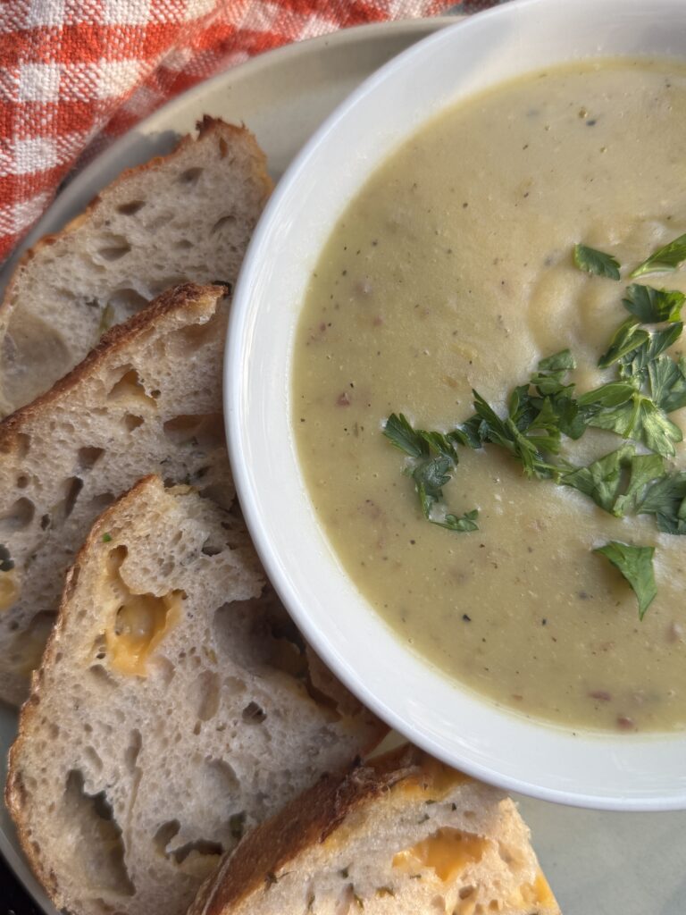 Creamy potato leek soup without cream served with cheddar and chive sourdough bread