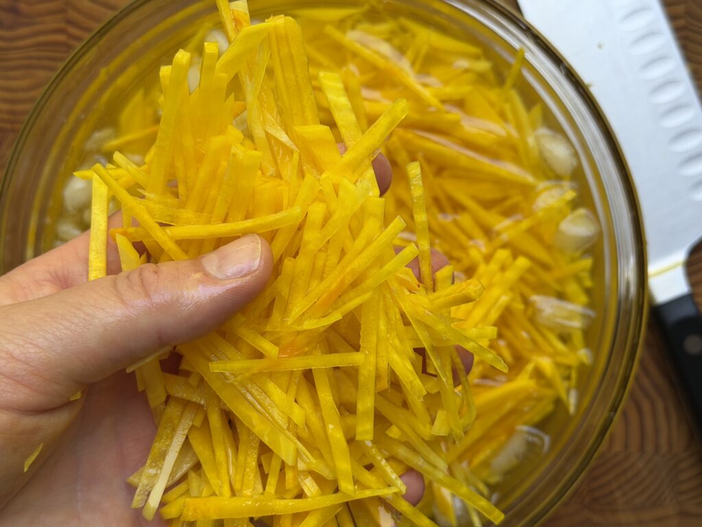 Golden beets sliced into strips and soaking in an ice bath to preserve crispness