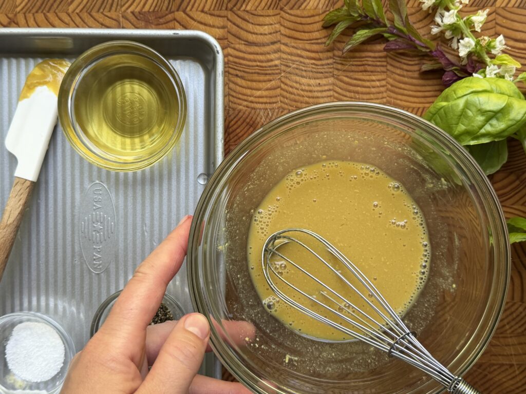 Lemon Dijon vinaigrette in a bowl with a whisk