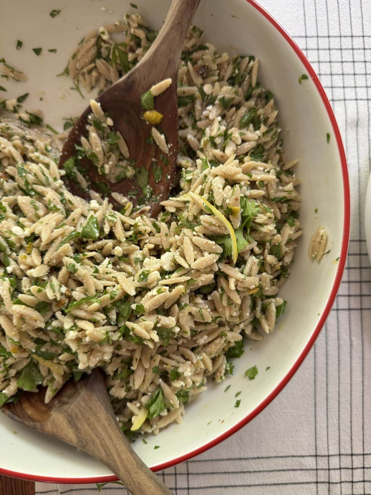 Serving bowl of Lemon Feta Orzo Pasta Salad with serving utensils