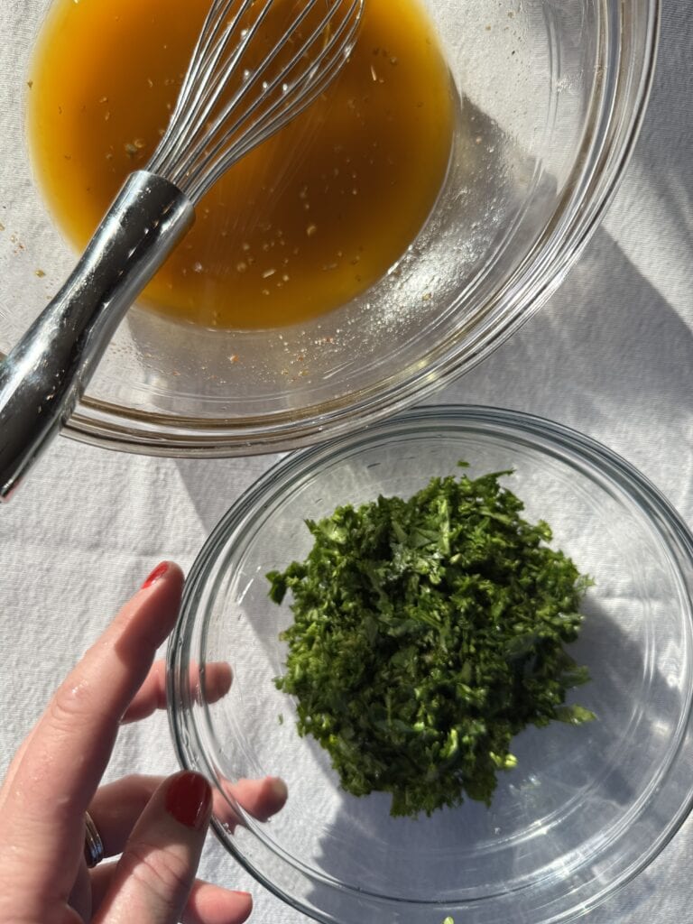 Oil and vinegar mixture with chopped herbs in a separate bowl