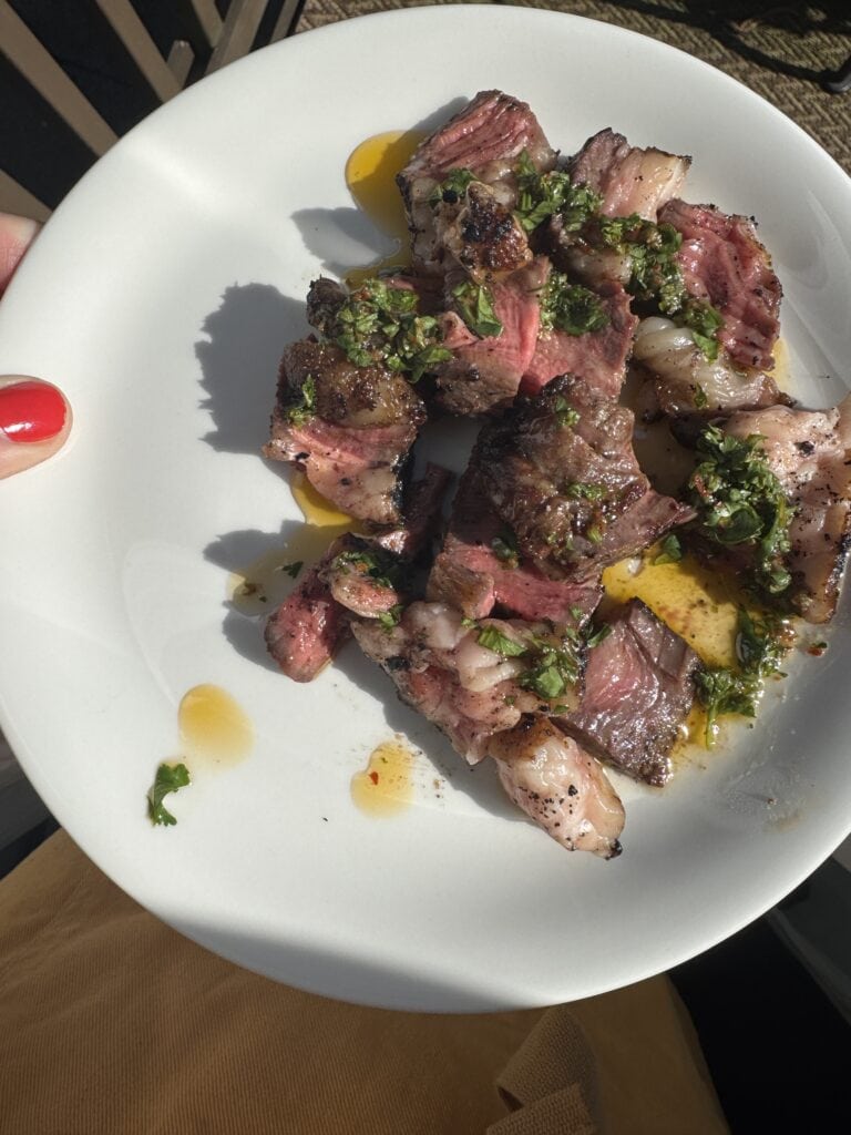 Plated ribeye steak with The Host Notes' cilantro chimichurri sauce