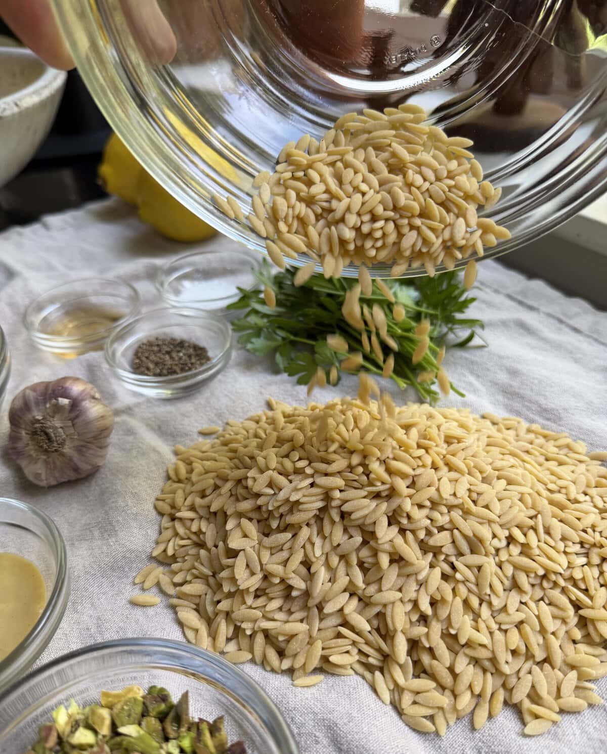 Ingredients for Lemon Orzo, including pasta, lemon, pistachios, olive oil, and seasonings