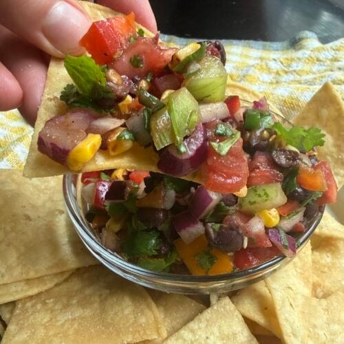 Prepared salsa in a clear bowl and tortilla chips.